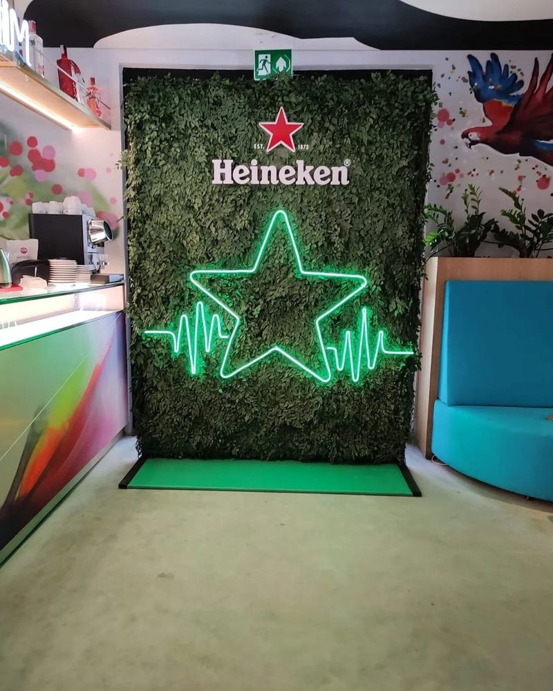 Backdrop de folhagem artificial Heineken com estrela neon em cafeteria