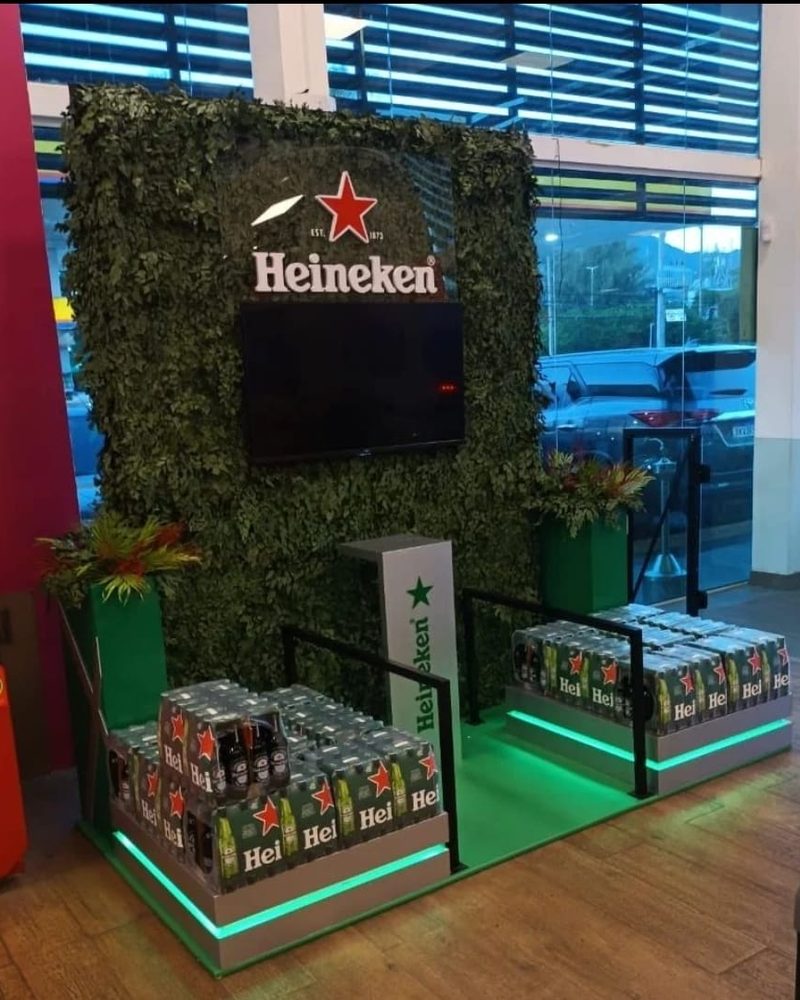 Display de ponto de venda Heineken com fundo de plantas artificiais