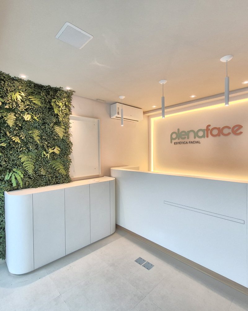 Jardim vertical de plantas artificiais na recepção da clínica PlenaFace